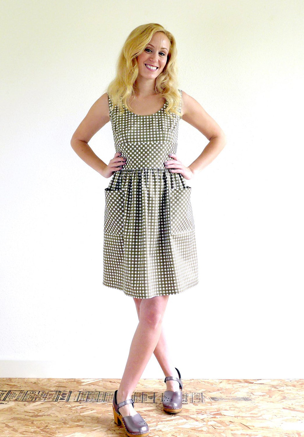 Woman wearing the Sylvie Dress sewing pattern from Christine Haynes on The Fold Line. A sleeveless dress pattern made in linen, lawn, shirting, or chambray fabrics, featuring a fit-and-flare style, darts under the bust, back waist darts, bias-bound neckli