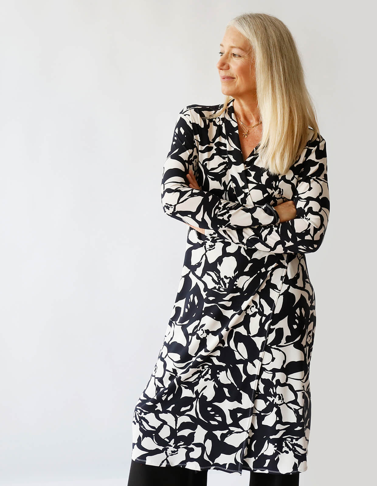 Woman wearing the Wrap Dress sewing pattern from The Maker's Atelier on The Fold Line. A wrap dress pattern made in fluid single jersey fabrics with lycra/elastane content, featuring a V-neck, overlong sleeves, tie waist closure and midi length.