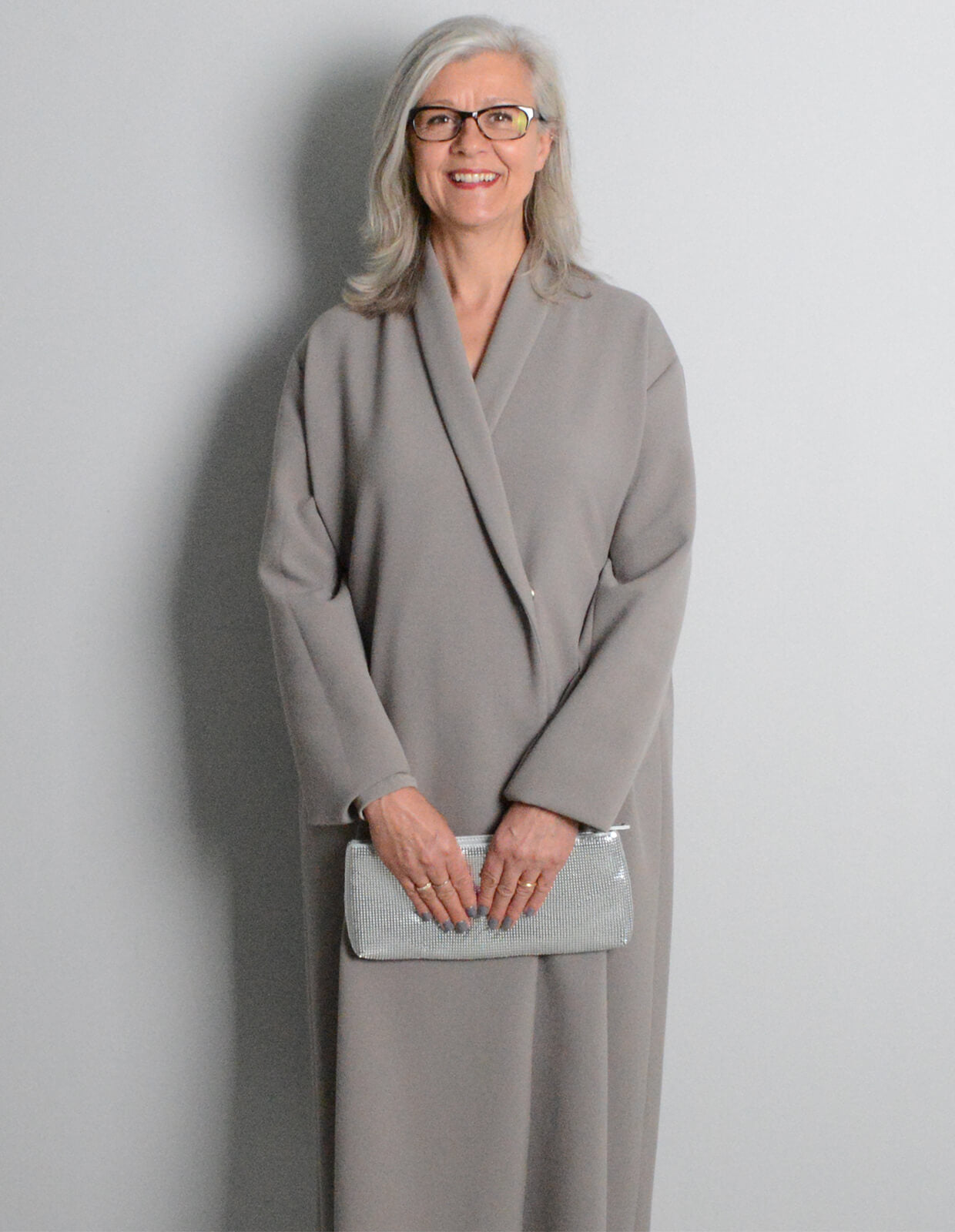 Woman wearing the Shawl Collar Coat sewing pattern from The Maker's Atelier on The Fold Line. A coat pattern made in melton or felted wool fabrics, featuring a raw edge, unlined, shawl collar, full length sleeve, midi length, single snap closure, relaxed 