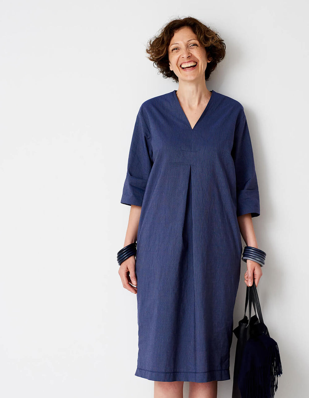 Woman wearing the V-neck Shift Dress sewing pattern from The Maker's Atelier on The Fold Line. A dress pattern made in cotton shirting, chambrays, lightweight linen, broderie anglaise, lightweight wool/viscose mixes, and babycord fabrics, featuring an inv