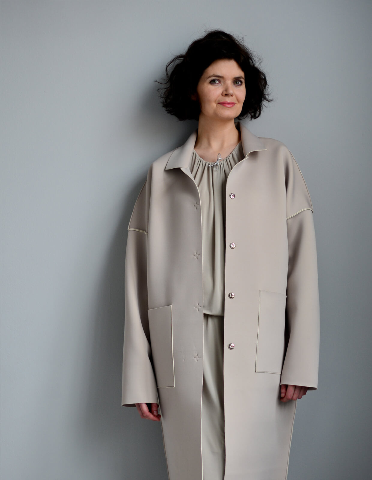 Woman wearing the Unlined Raw-edged Coat sewing pattern from The Maker's Atelier on The Fold Line. A coat pattern made in felted and boiled wools, hi-tech synthetics, neoprene and bonded fabrics, featuring dropped shoulders, patch pockets, over long sleev