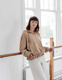 Woman wearing the Two Contemporary Sweatshirts sewing pattern from The Maker's Atelier on The Fold Line. A jersey top pattern made in medium weight jersey and sweatshirt fabrics, featuring a relaxed fit, hood with drawstring, gathered waist hem and gather