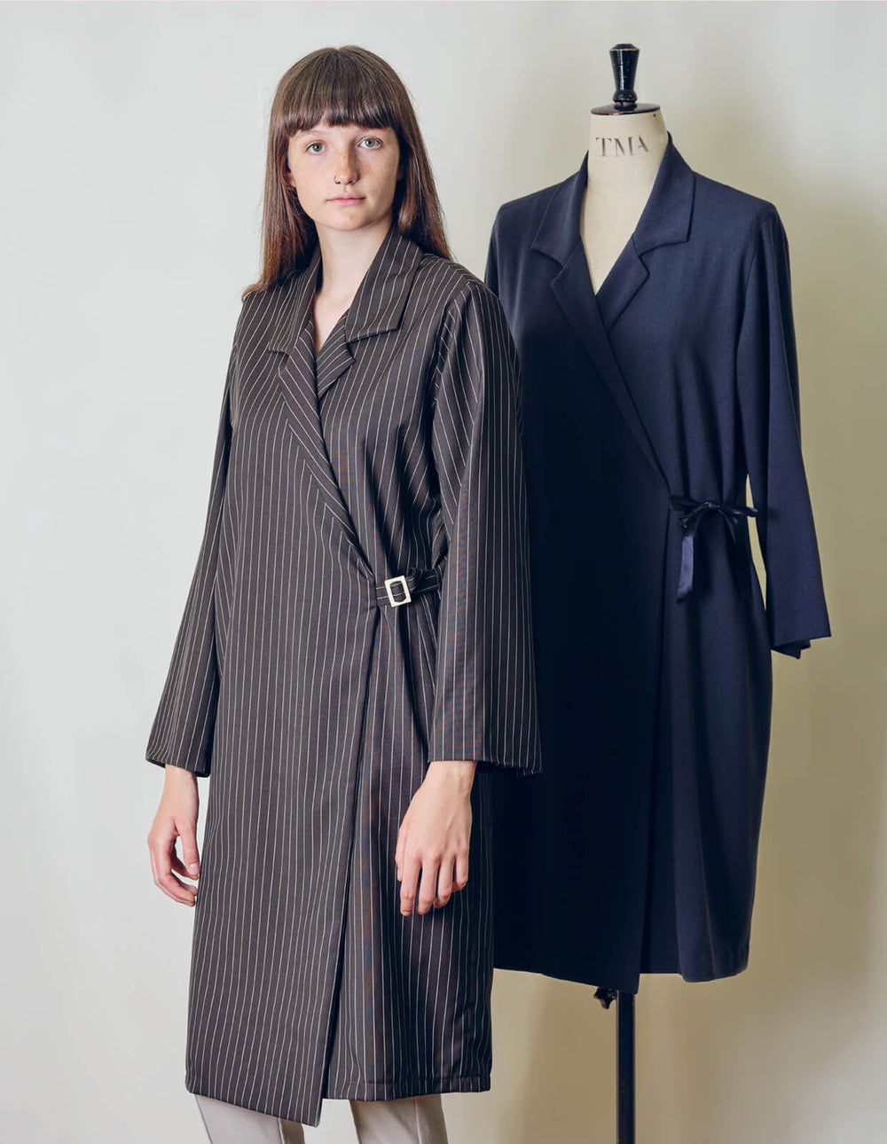 Woman wearing the Woven Wrap Dress sewing pattern from The Maker's Atelier on The Fold Line. A wrap dress pattern made in wool, denim, silk, linen or viscose fabrics, featuring a self-fabric strap and buckle closure, asymmetric hem, long sleeves, relaxed 