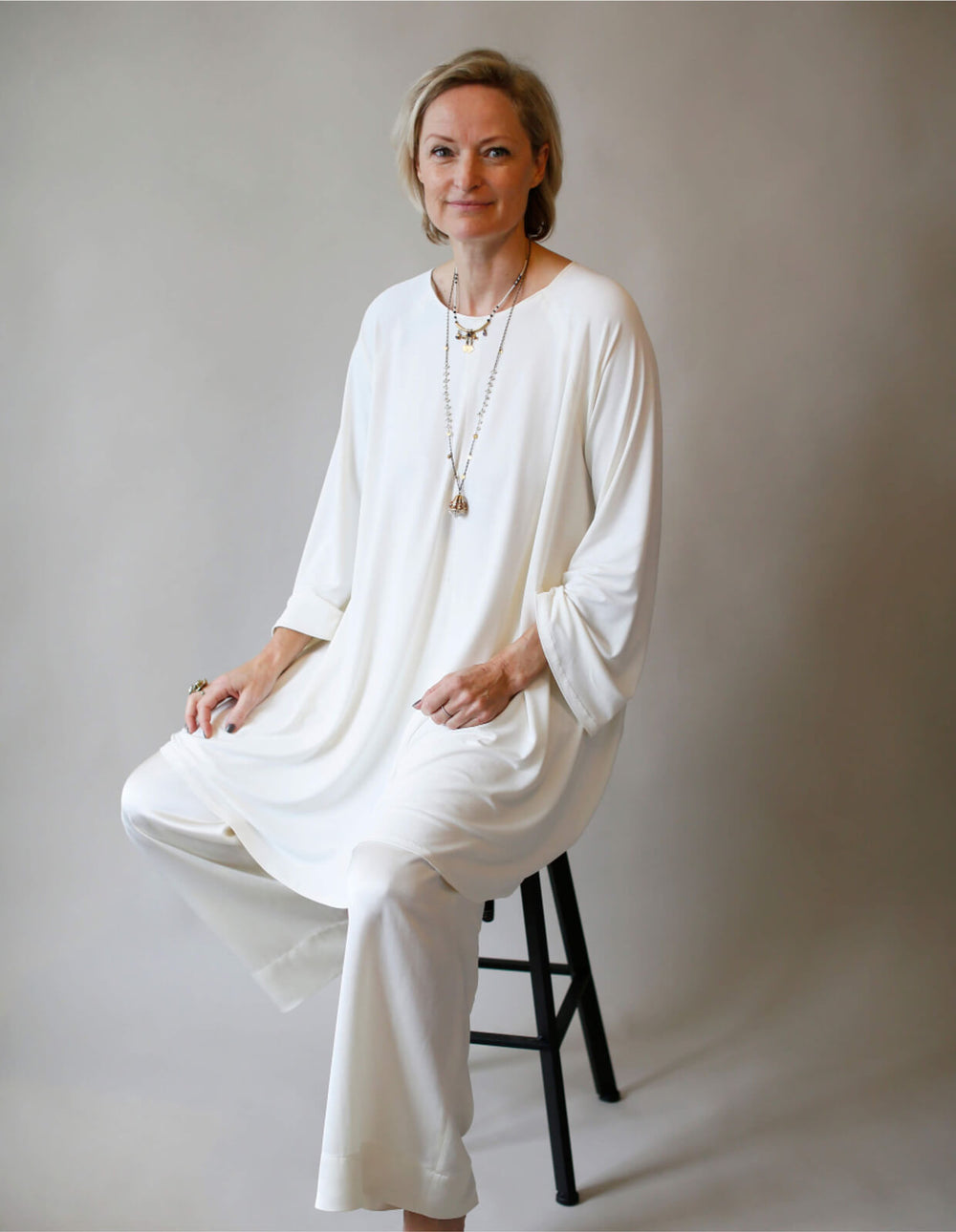 Woman wearing Flared Tunic sewing pattern from The Maker's Atelier on The Fold Line. A tunic pattern made in cotton terry and loopback, microfleece, viscose jersey and boiled wool fabrics, featuring a round neck, oversized fit, A-line shape, and long slee