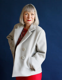 Woman wearing the Pea Coat sewing pattern from The Maker's Atelier on The Fold Line. A buttoned, double breasted coat pattern made in medium weight coating fabrics, wools, wool melton, tweeds, velvet or corduroys fabrics, featuring deep cuffs, back has ha