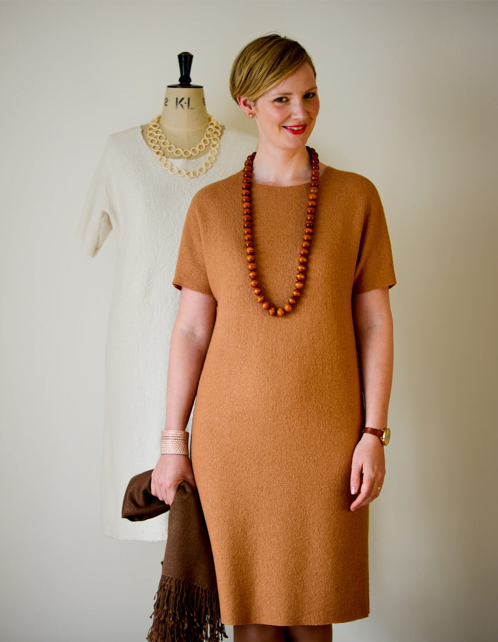 Woman wearing the Shell Dress sewing pattern from The Maker's Atelier on The Fold Line. A dress pattern made in felted and boiled wools or neoprene fabrics, featuring a shell shape, diamond insert under the arm, round neck, short sleeves, knee length hem 