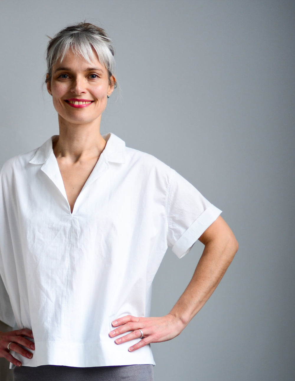 Woman wearing the Holiday Shirt sewing pattern from The Maker's Atelier on The Fold Line. A top pattern made in cottons, linens, lightweight waterproof fabrics and oilskins fabrics, featuring a boxy silhouette, pull-on style, collar, V-neck, and short sle