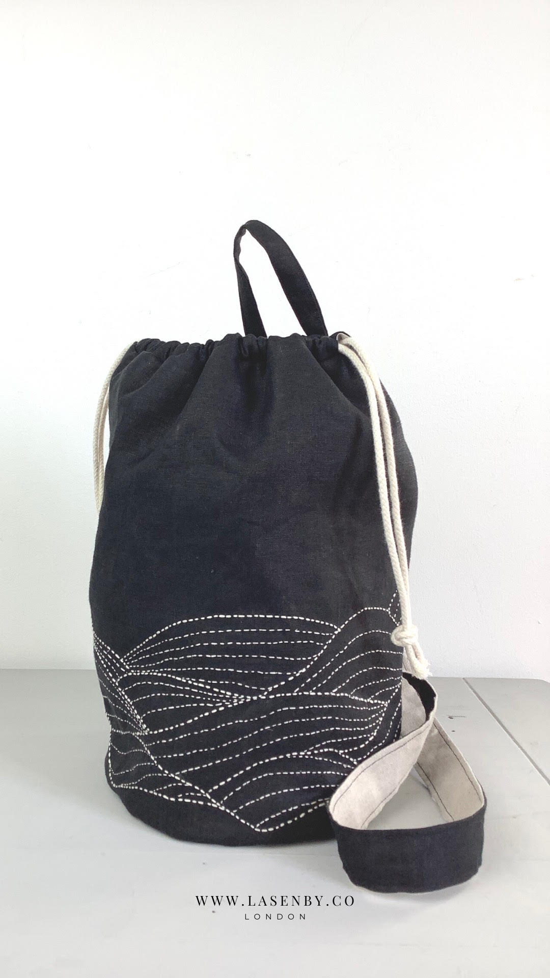 Photo showing the Taru Tide Crossbody Duffle Bag sewing pattern from Lasenby on The Fold Line. A duffle bag pattern made in canvas, linen, quilting cotton, twill, duck, denim, fine tweed, and Tana lawn fabrics, featuring a sashiko embroidery design, back 