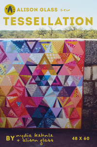 Photo showing the Tessellation Quilt sewing pattern from Alison Glass on The Fold Line. A quilt pattern made in quilting cotton fabrics, featuring a design using triangles of all sizes and shapes in a rainbow of colours.