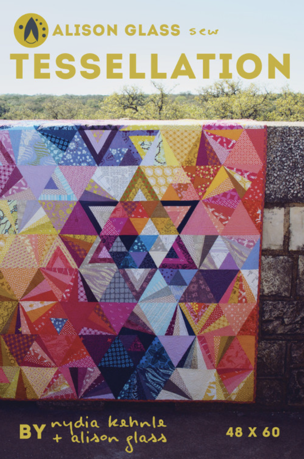 Photo showing the Tessellation Quilt sewing pattern from Alison Glass on The Fold Line. A quilt pattern made in quilting cotton fabrics, featuring a design using triangles of all sizes and shapes in a rainbow of colours.