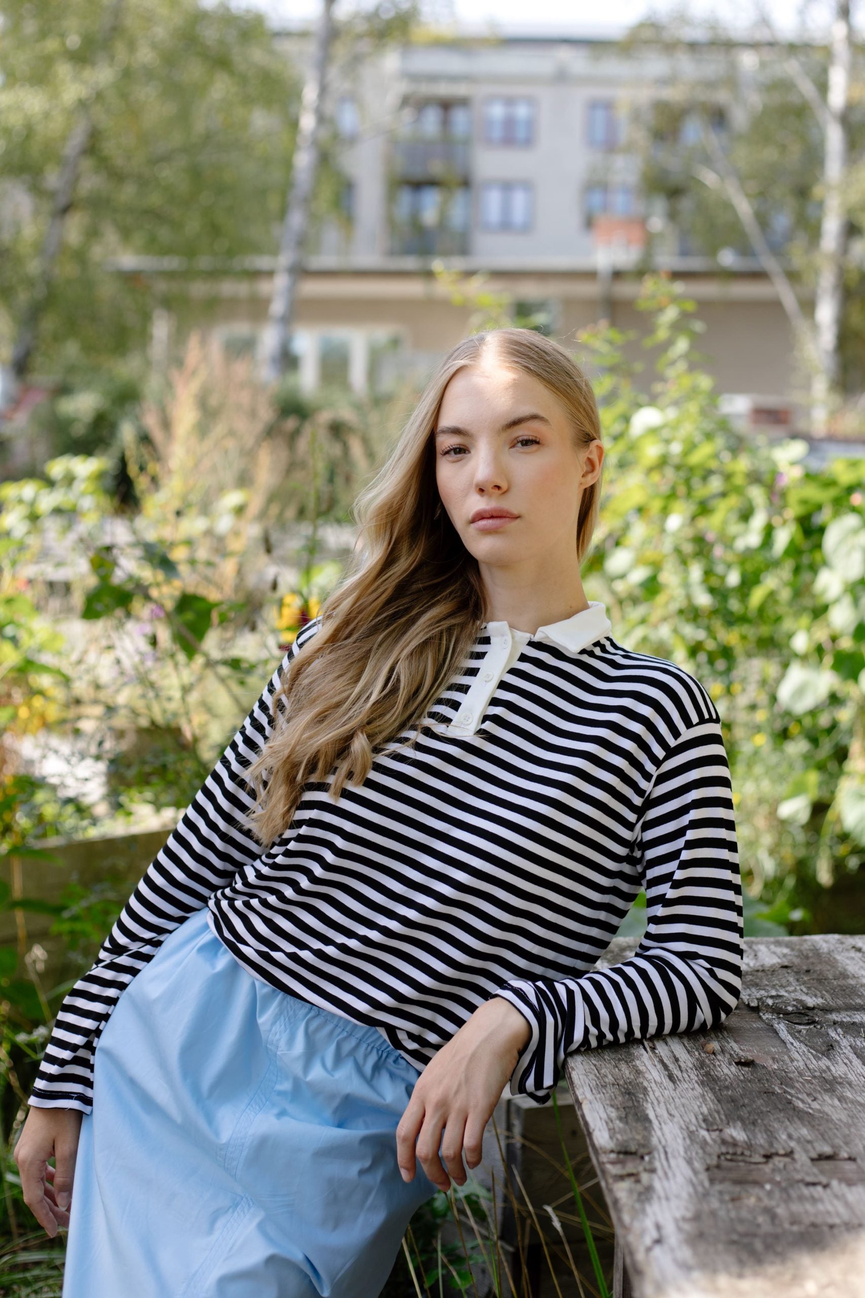 Woman wearing the Pippa Polo sewing pattern from JULIANA MARTEJEVS on The Fold Line. A knit top pattern made in cotton jersey fabrics, featuring a 3-button placket, collar and stand, full length sleeves and relaxed fit.