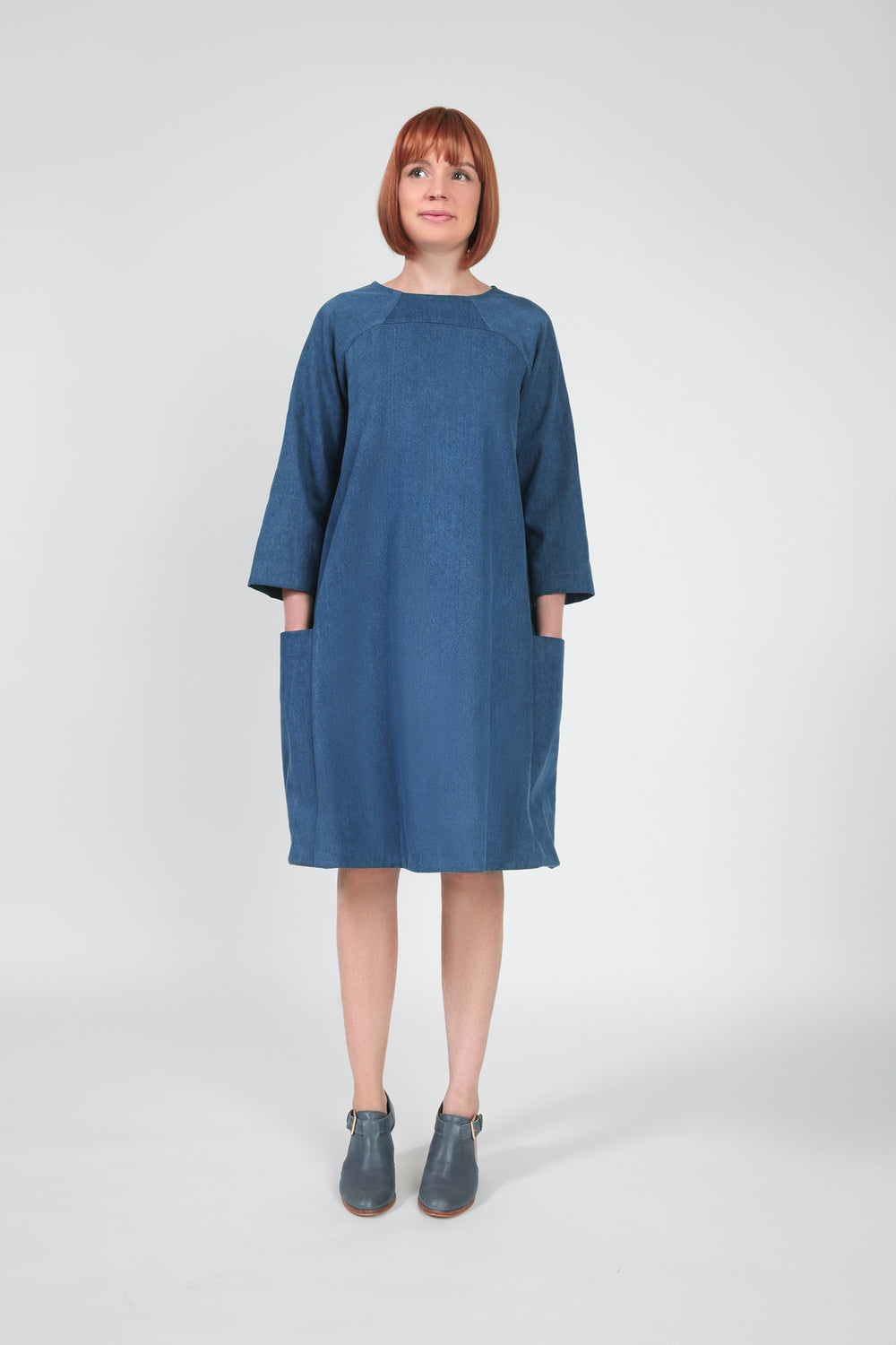 Woman wearing the Rushcutter Dress pattern from In the Folds on The Fold Line. A knee length dress pattern made in cotton shirting, poplin, sateen, linen, silk, wool, chambray, denim, viscose blend or silk crepe de chine fabrics, featuring an A-line shape