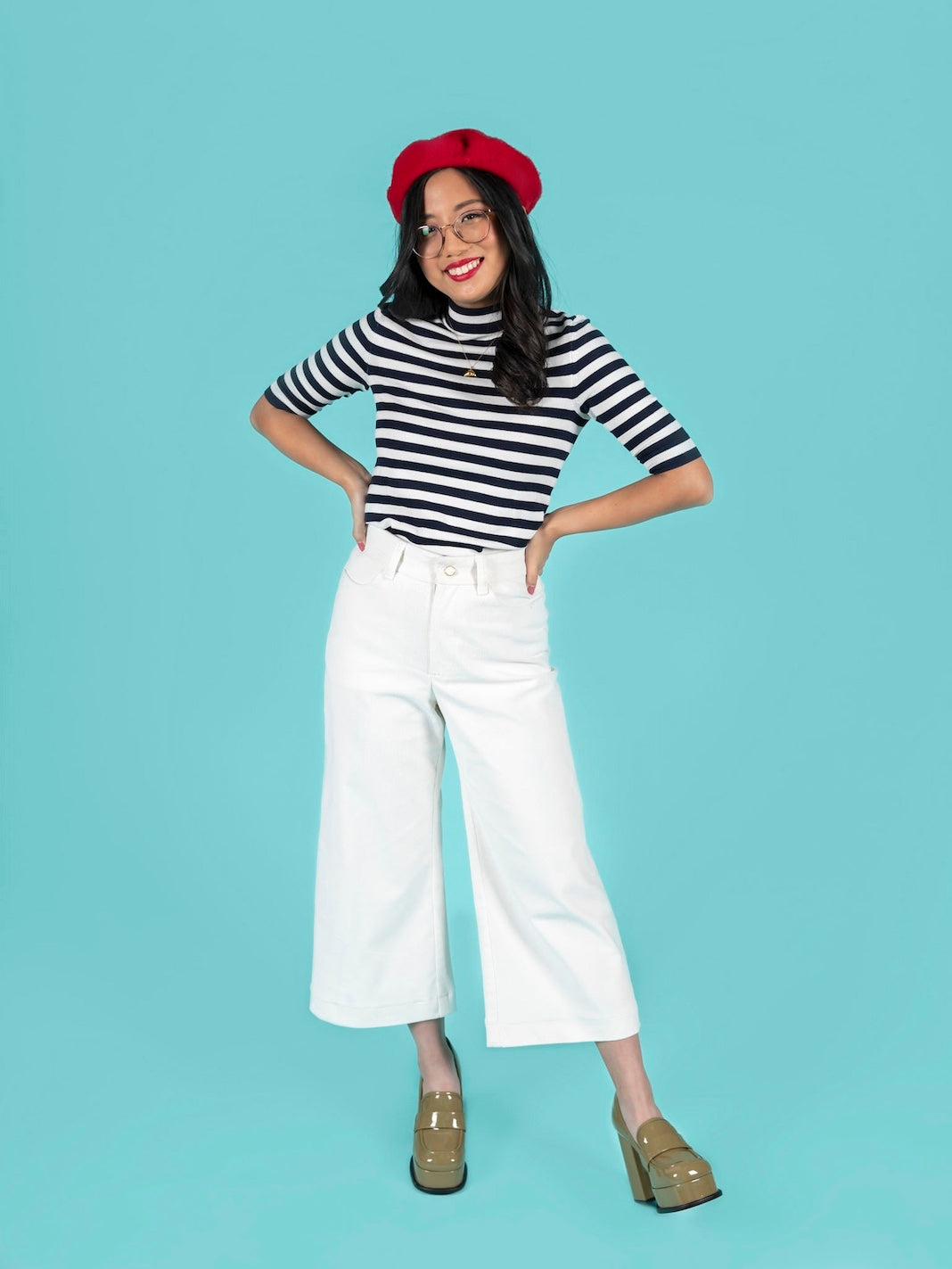 Woman wearing the Thea Trousers sewing pattern from Tilly and the Buttons on The Fold Line. A trousers pattern made in linen, twill, denim, corduroy, triple crêpe, or wool suiting fabric, featuring wide legs, a high waist, zip fly, pockets, belt loops, an