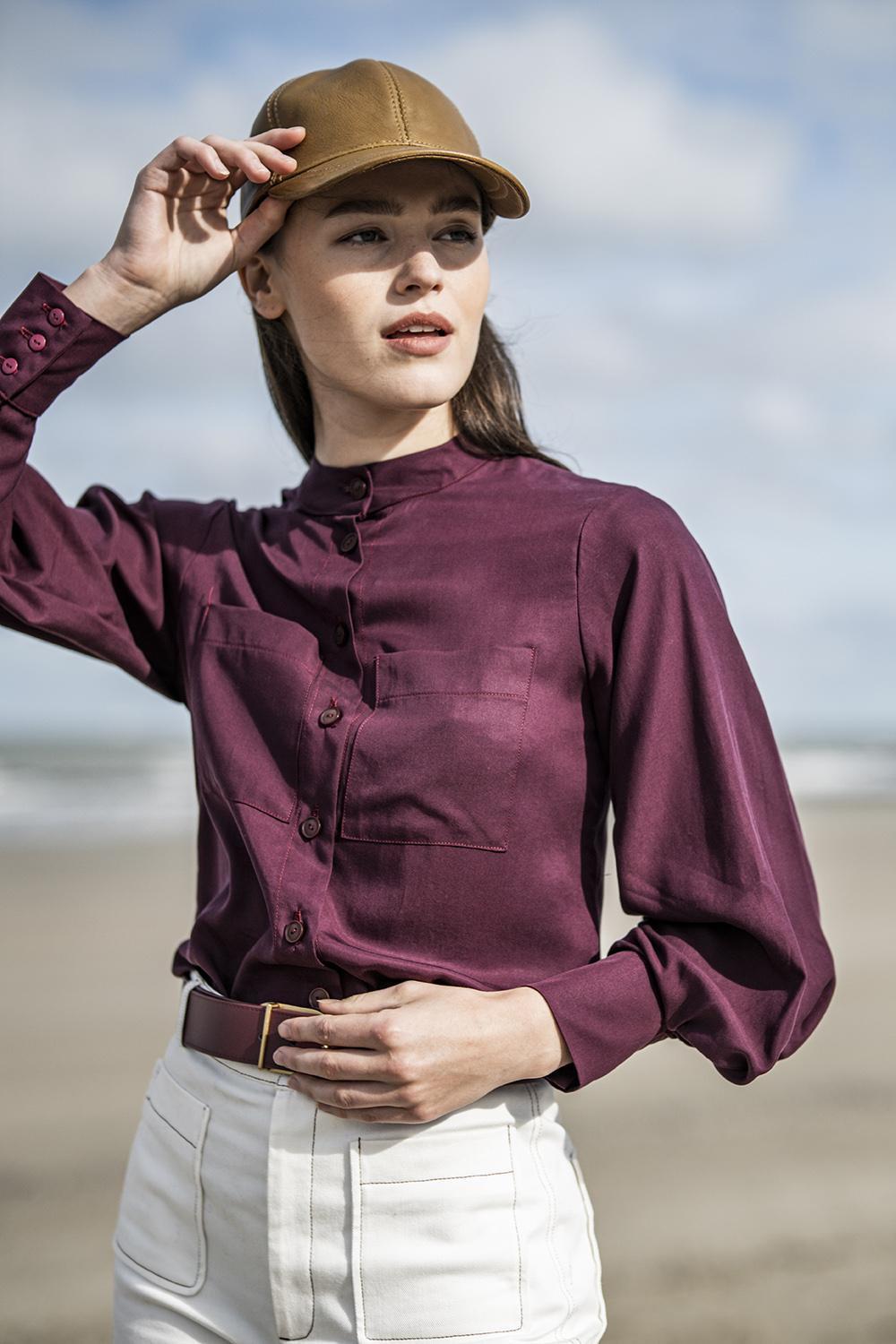 Woman wearing the Tilly Blouse sewing pattern from Fibre Mood on The Fold Line. A top pattern made in viscose, lyocell, poplin, chambray, lace or baby wale corduroy fabrics, featuring an officer collar, sleeve hem pleats, button wrist trim, patch pockets 