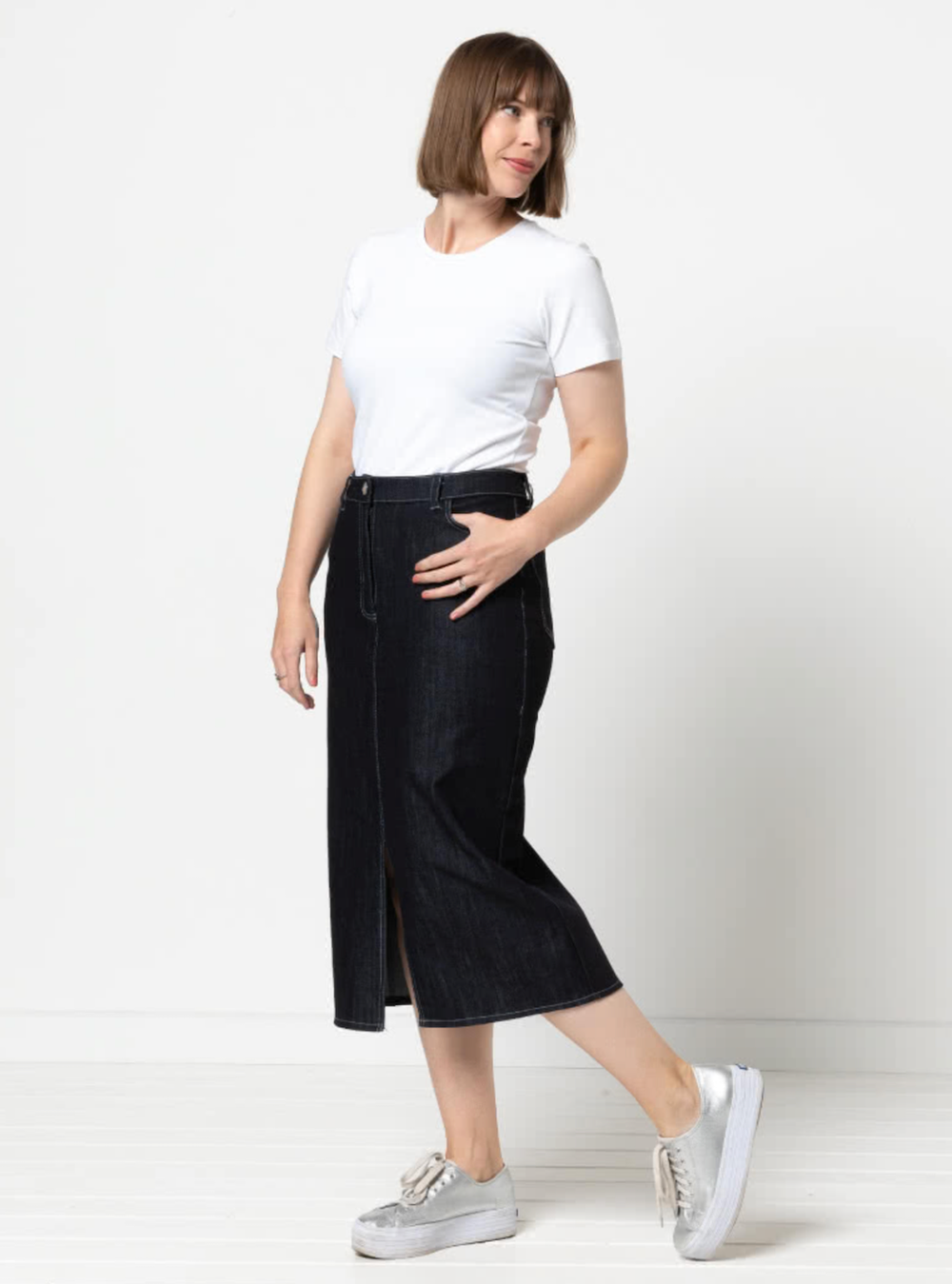 Women wearing the Tommie Jeans Skirt sewing pattern from Style Arc on The Fold Line. A skirt pattern made in denim, drill or linen fabrics, featuring a calf length, front split, straight shape, fly zip closure, front and back pockets, and shaped waistband