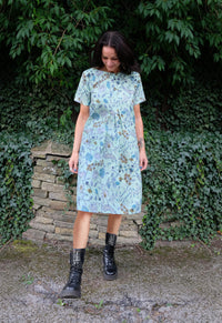Woman wearing the Triple Tuck Smock sewing pattern from Sew Different on The Fold Line. A dress pattern made in cotton, linen, viscose, denim, needlecord, wool or jersey fabrics, featuring a loose-fit, three front pleats, elbow-length raglan sleeves, roun