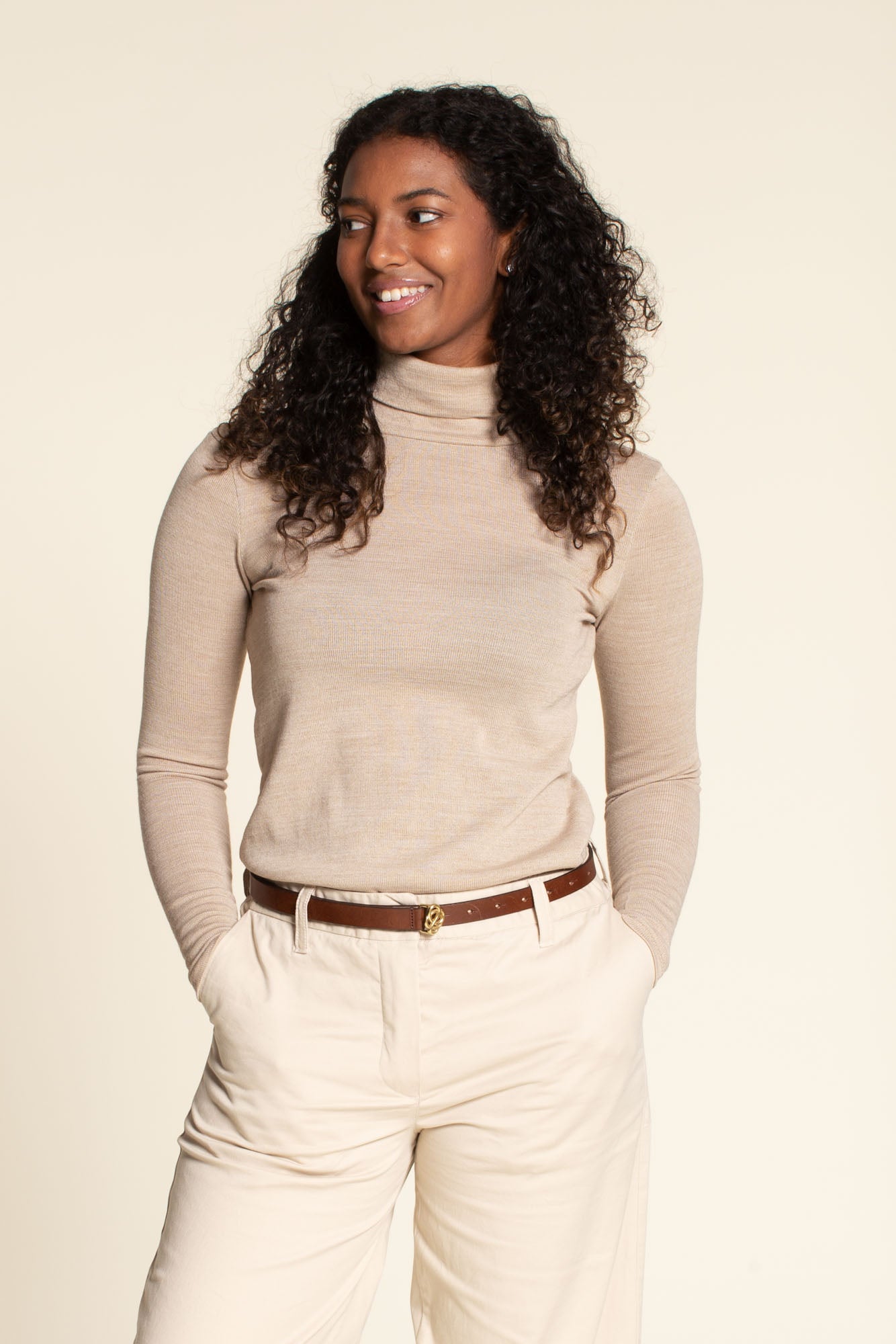 Woman wearing the Trudy Turtleneck sewing pattern from Wardrobe by Me on The Fold Line. A fitted top made in light to medium weight jersey fabrics, featuring a turtleneck, full length sleeves and straight hem.