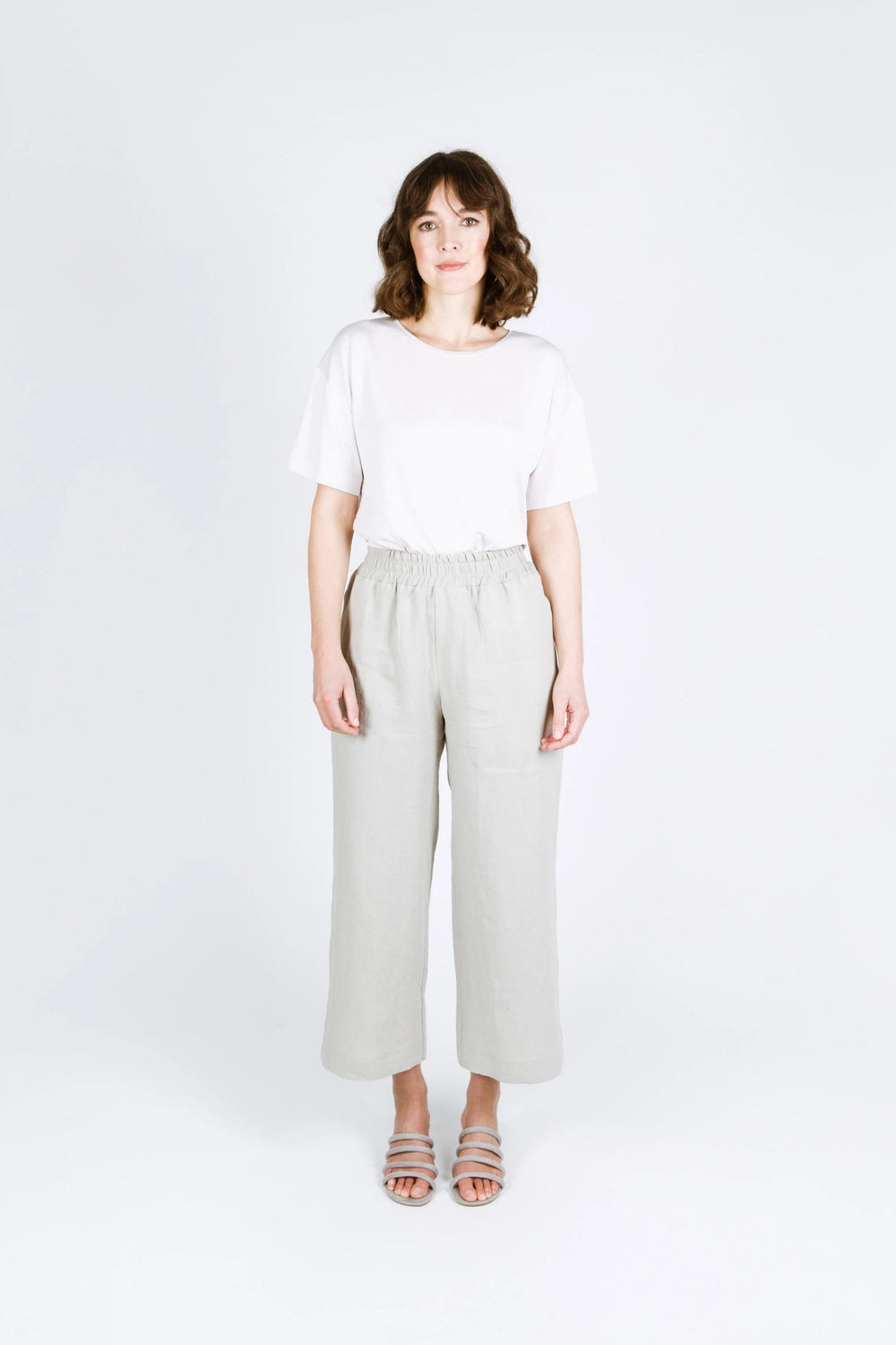 Woman wearing the Tula Pants sewing pattern from Papercut Patterns on The Fold Line. A trouser pattern made in linen, cotton, sweatshirting and blended fabrics, featuring an elasticated waistband, side pockets, relaxed fit, wide leg, and cropped length.