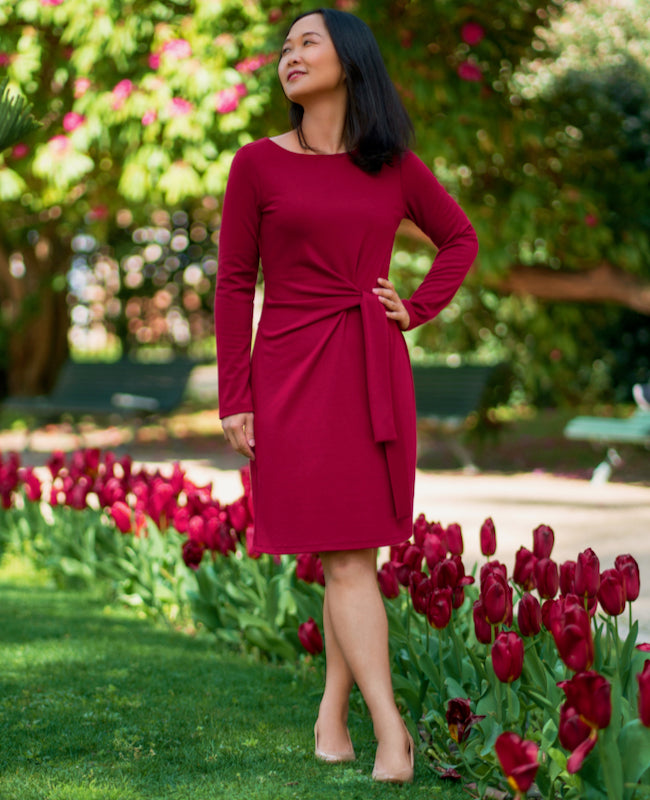 Woman wearing the Tustin Dress sewing pattern from Itch to Stitch on The Fold Line. A dress pattern made in interlock, ponte, cotton Lycra jersey or double-brushed poly fabrics, featuring a waist tie that emerges from the centre front, full length sleeves