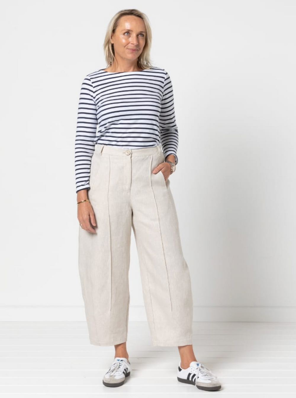 Woman wearing the Twig Woven Pant sewing pattern from Style Arc on The Fold Line. A pants or jeans pattern made in denim, drill, cotton, or linen fabric, featuring a fly front, in-seam pockets, elastic back waistband, front and back leg pintucks, and a cr