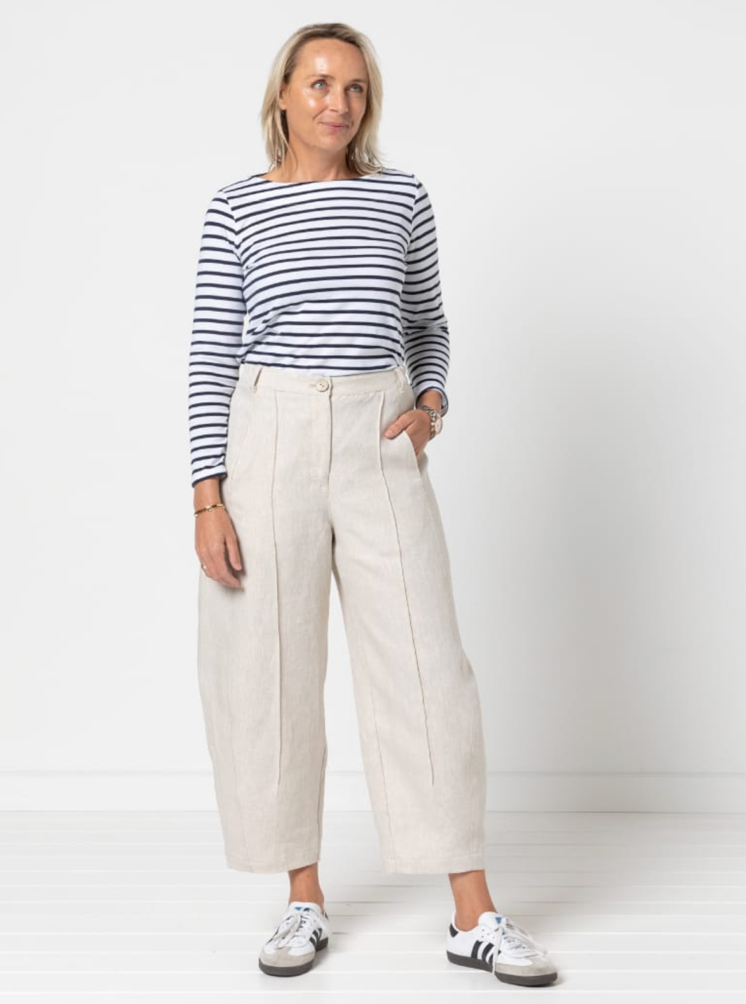 Woman wearing the Twig Woven Pant sewing pattern from Style Arc on The Fold Line. A pants or jeans pattern made in denim, drill, cotton, or linen fabric, featuring a fly front, in-seam pockets, elastic back waistband, front and back leg pintucks, and a cr