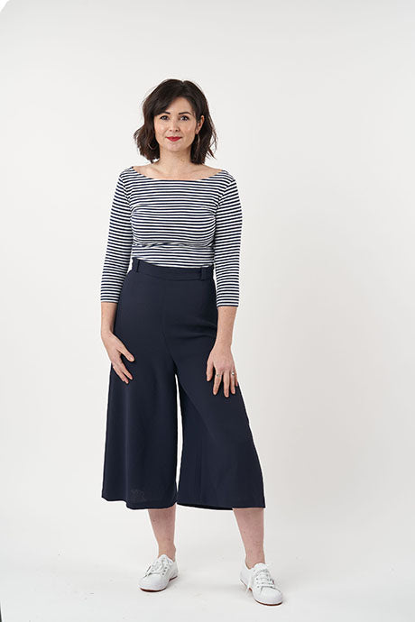 Woman wearing the Ultimate Culottes sewing pattern from Sew Over It on The Fold Line. A culottes pattern made in linen, crepe, suiting wool, viscose linen, or rayon fabric, featuring wide legs, darts at the front and back, a side invisible zip, and croppe
