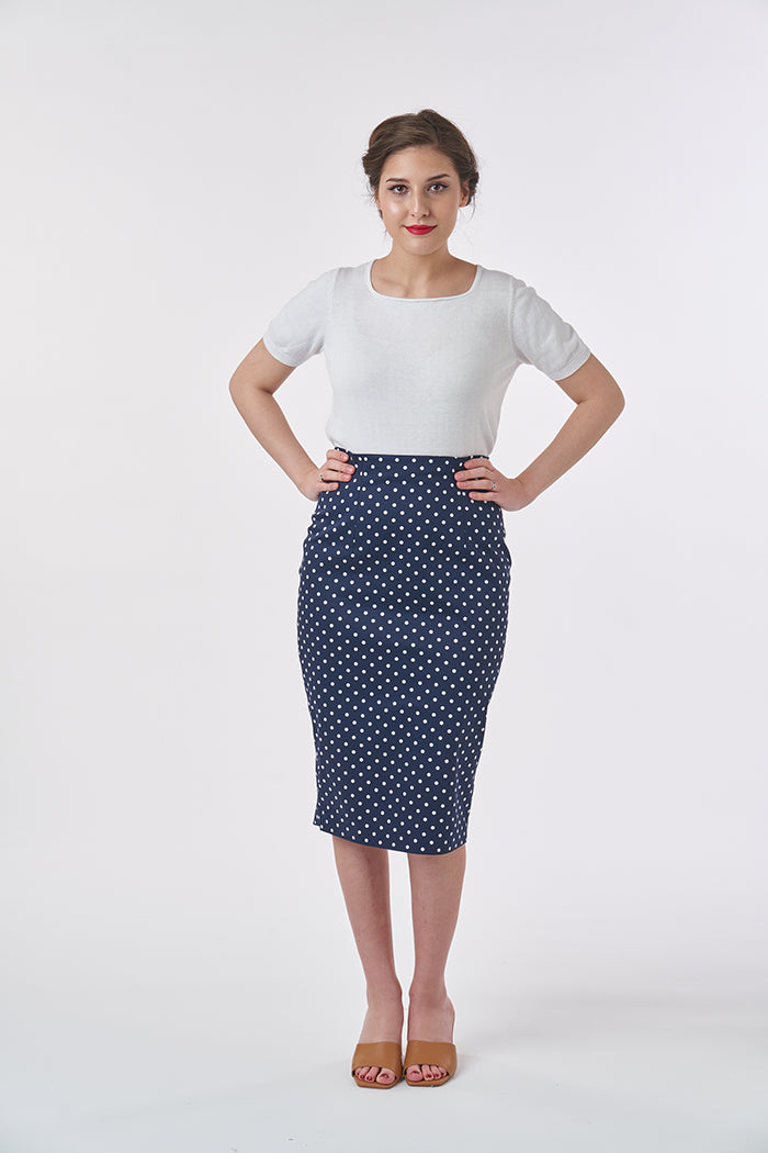 Woman wearing the Ultimate Pencil Skirt sewing pattern from Sew Over It on The Fold Line. A pencil skirt pattern made in medium weight cotton, wool, crepe, or suiting fabrics, featuring a high-waist, back kick pleat, waist facing, front and back darts, an