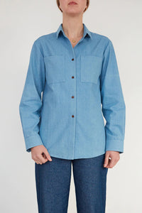 Woman wearing the Unisex Shirt sewing pattern from The Modern Sewing Co on The Fold Line. A shirt pattern made in poplin, lightweight twill or denim fabrics, featuring a boxy silhouette, collar and stand, front button closure, chest patch pockets, full le