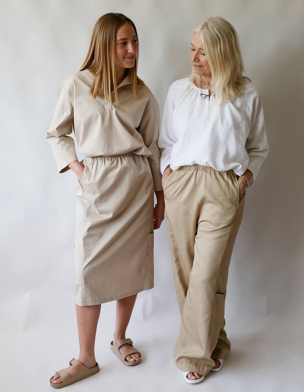 Women wearing the Utility Pant and Skirt sewing pattern from The Maker's Atelier on The Fold Line. A trouser and skirt pattern made in cupro, Tencel, and viscose mixed fabrics, featuring pockets and patch pockets, relaxed fit, elasticated waists, below kn