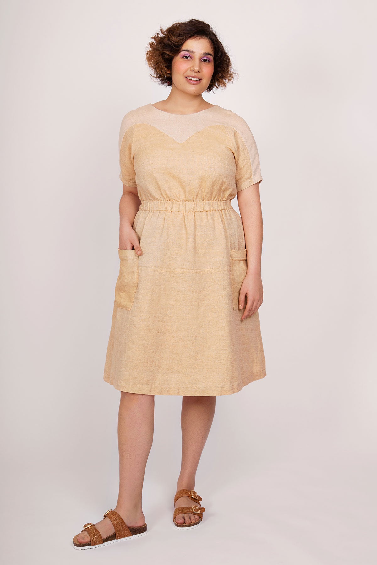 Woman wearing the Valo Dress sewing pattern from Named on The Fold Line. A dress pattern made in non-stretch, medium weight fabrics such as linen fabrics, featuring an elasticated waist, large patch pockets, relaxed-fit, heart-shaped yoke with a scoop nec