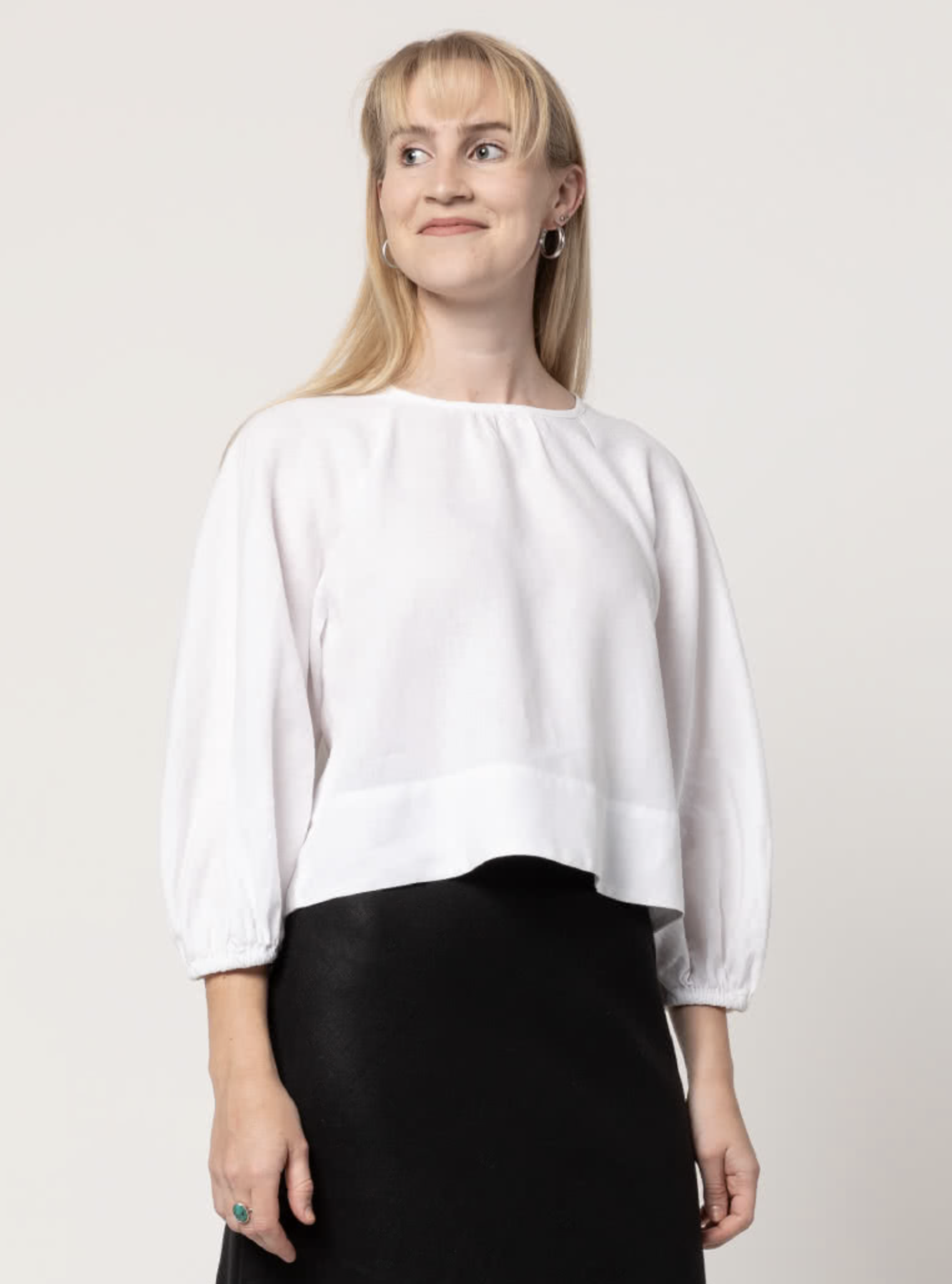 Woman wearing the Verona Woven Top sewing pattern from Style Arc on The Fold Line. A top pattern made in linen or cotton fabrics, featuring a pull-on style, square-shaped body, high hip length, raglan 3/4-length bias-cut sleeves with elastic cuff, gathere