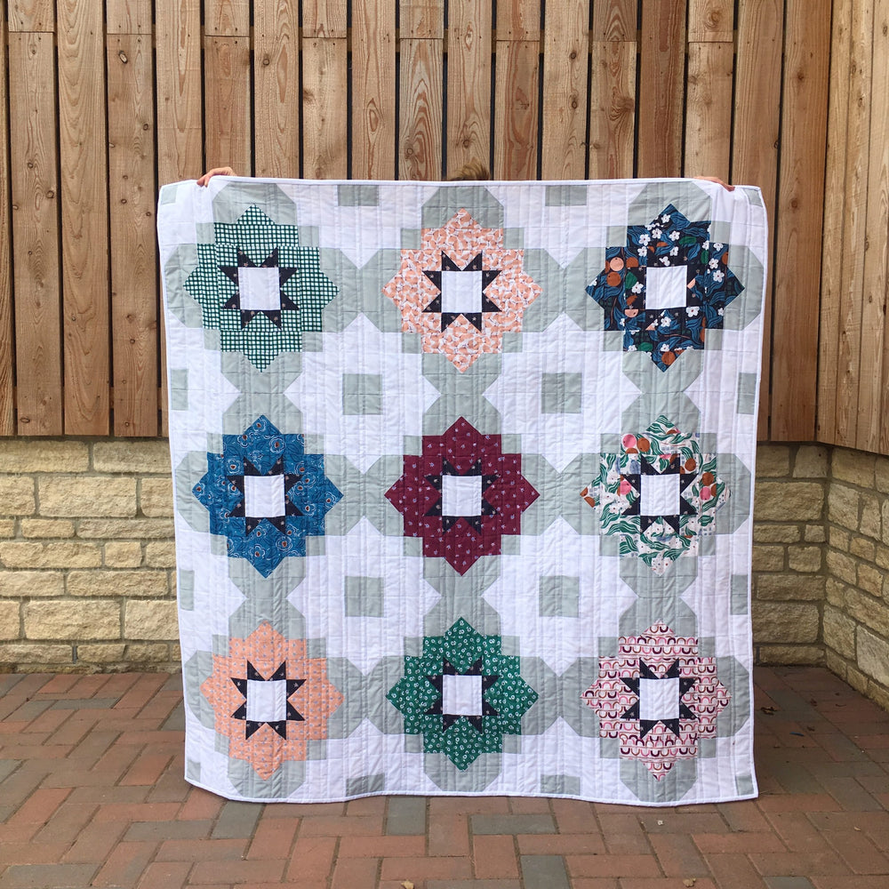 Photo showing the Vintage Tiles Quilt sewing pattern from Lou Orth Designs on The Fold Line. A quilt pattern made in quilting cotton fabrics, featuring a modern yet timeless design that is fat quarter friendly and great for showcasing some of your favouri