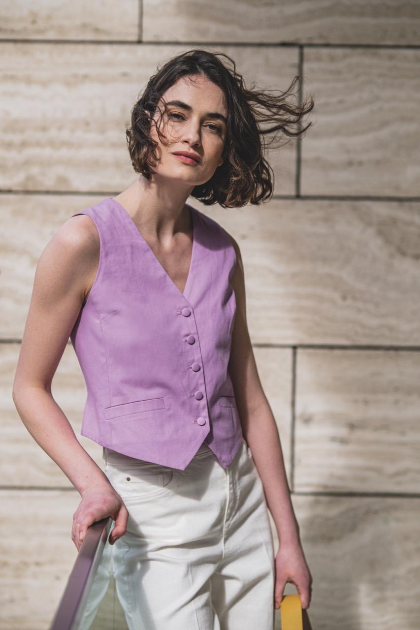 Woman wearing the Vivienne Waistcoat sewing pattern from Fibre Mood on The Fold Line. A vest pattern made in cotton twill, denim, fine corduroy, medium to heavy weight linen or gabardine fabrics, featuring a relaxed fit, lined, side panels, button front a