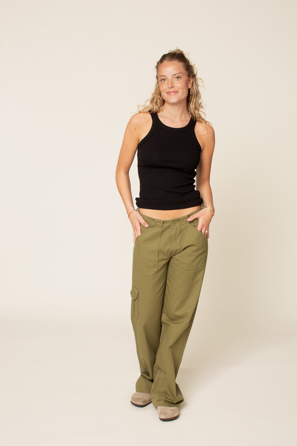 Woman wearing the Cargo Pants sewing pattern from Wardrobe by Me on The Fold Line. A trouser pattern made in bottom-weight cotton, linen, canvas, denim, or ripstop fabrics, featuring a relaxed fit, below navel waistline, zip fly, belt loops, five patch po