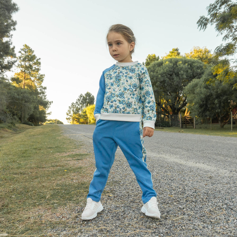 Child wearing the Children's Sweatpants sewing pattern from Wardrobe by Me on The Fold Line. A joggers pattern made in sweatshirt fleece, interlock, or medium weight jersey fabrics, featuring a classic straight-leg, side seam pockets, ribbed waistband wit