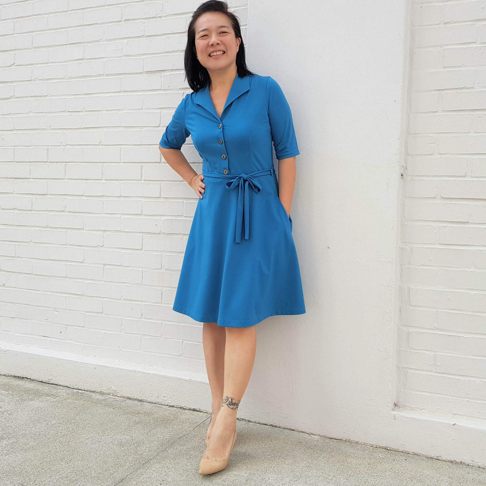 Woman wearing the Marianne Dress sewing pattern from Wardrobe by Me on The Fold Line. A dress pattern made in light to medium weight jersey fabrics, featuring front buttons, A-line skirt, self-fabric belt, in-seam pockets, fitted bodice, front and back da