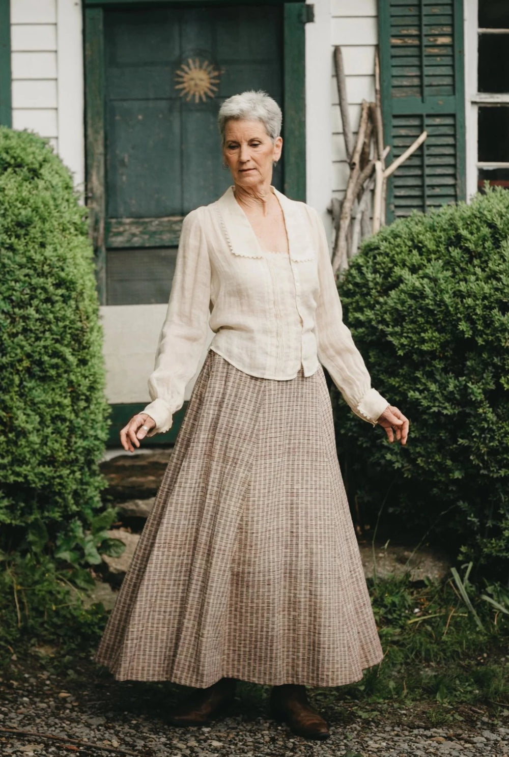 Woman wearing the 209 Walking Skirt sewing pattern from Folkwear on The Fold Line. A gored skirt pattern made in medium to heavyweight cottons and blends, linen, silk, lightweight wool, thin-wale corduroy, and velvet fabrics, featuring a fitted front, gat