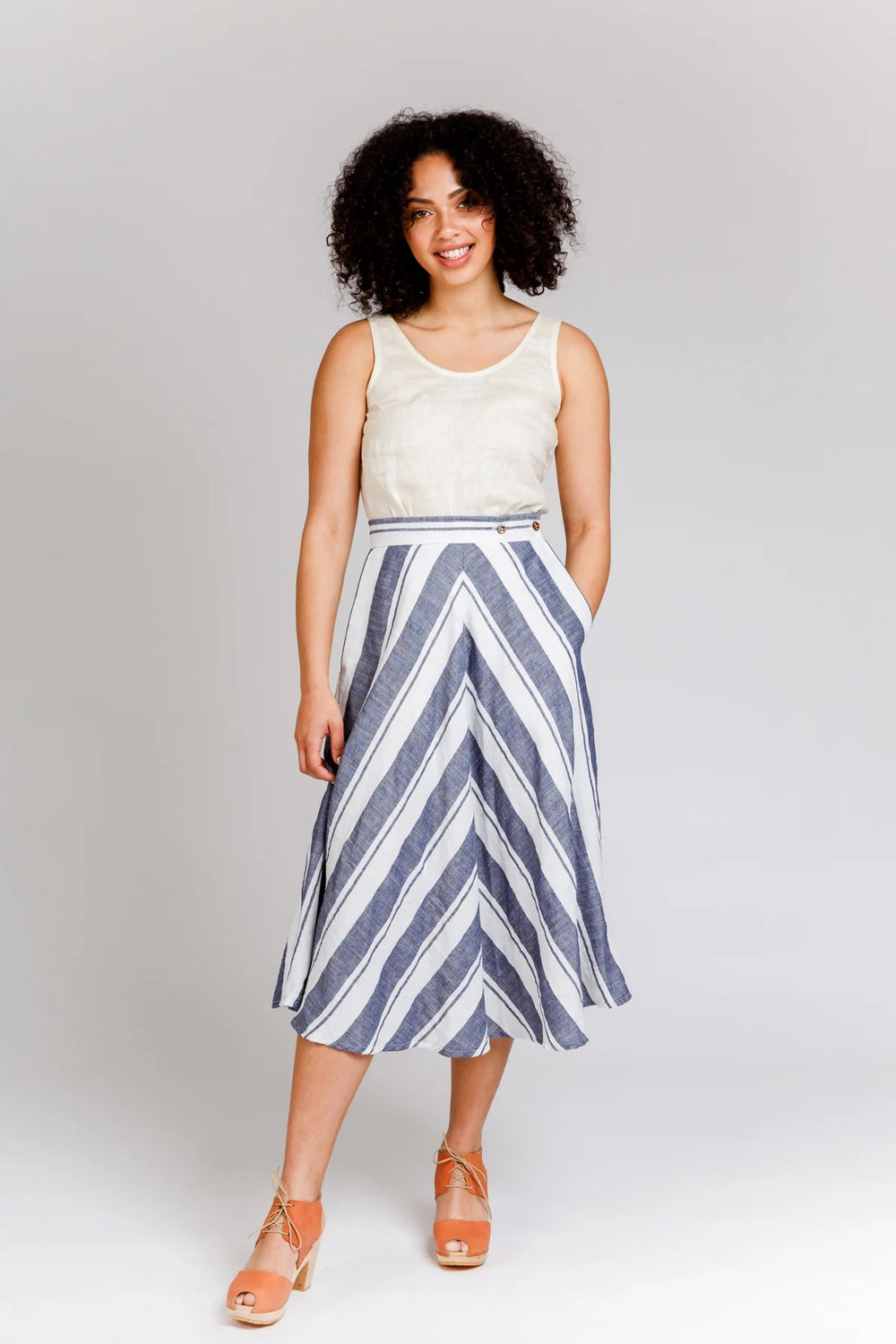Woman wearing the Wattle Skirt sewing pattern from Megan Nielsen on The Fold Line. A skirt pattern made in denim, twill, poplin, broadcloth, linens, suiting, gabardine, pique, wool blends, cottons, rayon, or silks fabrics, featuring a midi length, bias cu
