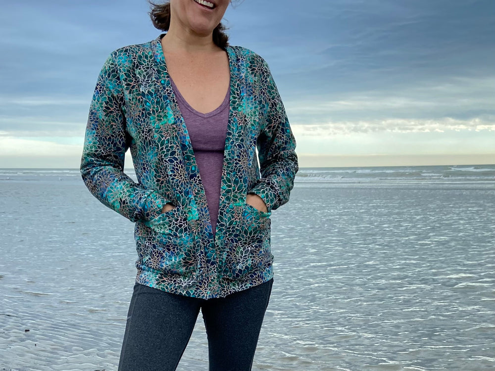Woman wearing the Women's Salt Air Cardigan sewing pattern from Waves & Wild on The Fold Line. A cardigan pattern made in medium weight knits such as cotton/Lycra french terry or sweatshirt fleece fabrics, featuring a slim-fit two length options, optional