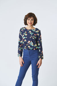 Woman wearing the Whitley Top sewing pattern from Sew Over It on The Fold Line. A top pattern made in cotton, cotton lawn, linen, or for a softer look, rayon or crepe fabrics, featuring a round neck, long sleeves, bust cup sizes, and back neck slit with h