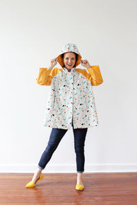 Woman wearing the Whitney Raincoat sewing pattern by Amy Nicole. A raincoat pattern made in waterproof or water resistant fabrics, featuring raglan sleeves, in-seam pockets and a roomy hood.