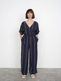 Woman wearing the Wide-Leg Jumpsuit sewing pattern from The Assembly Line on The Fold Line. A jumpsuit pattern made in light to medium weight fabrics such as cotton twill or viscose, featuring a relaxed fit, wide legs, dropped shoulder, front and back V-n