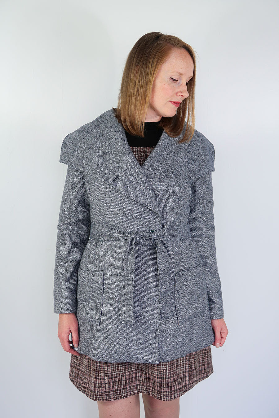 Woman wearing the Willa Wrap Coat sewing pattern from Jennifer Lauren Handmade on The Fold Line. A wrap coat pattern made in melton, boucle, herringbone, tweed, suitings, corduroy and light quilted fabrics, featuring a wide collar, semi-fitted, darted fro