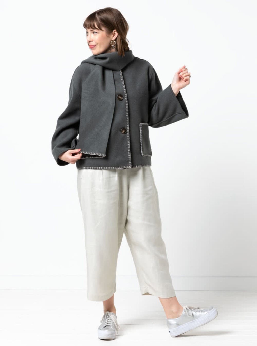 Woman wearing the Wren Jacket sewing pattern from Style Arc on The Fold Line. An unlined jacket and scarf pattern made in melton, boiled wool, wool coating, or linen fabric, featuring a square shaped jacket with a round neck, dropped shoulder line, button