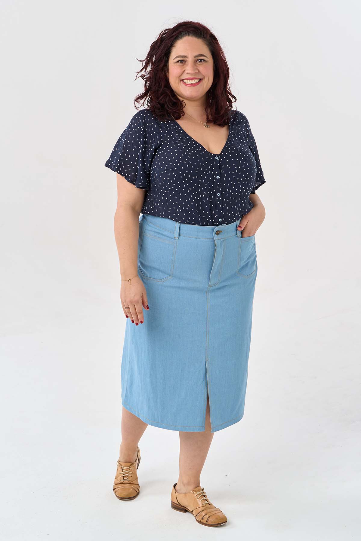 Woman wearing the Xanthe Skirt sewing pattern from Sew Over It on The Fold Line. A skirt pattern made in non-stretch denim, corduroy, or twill fabric, featuring a straight fit, zip fly, belt loops, shaped back yoke, back patch pockets, inset front pockets