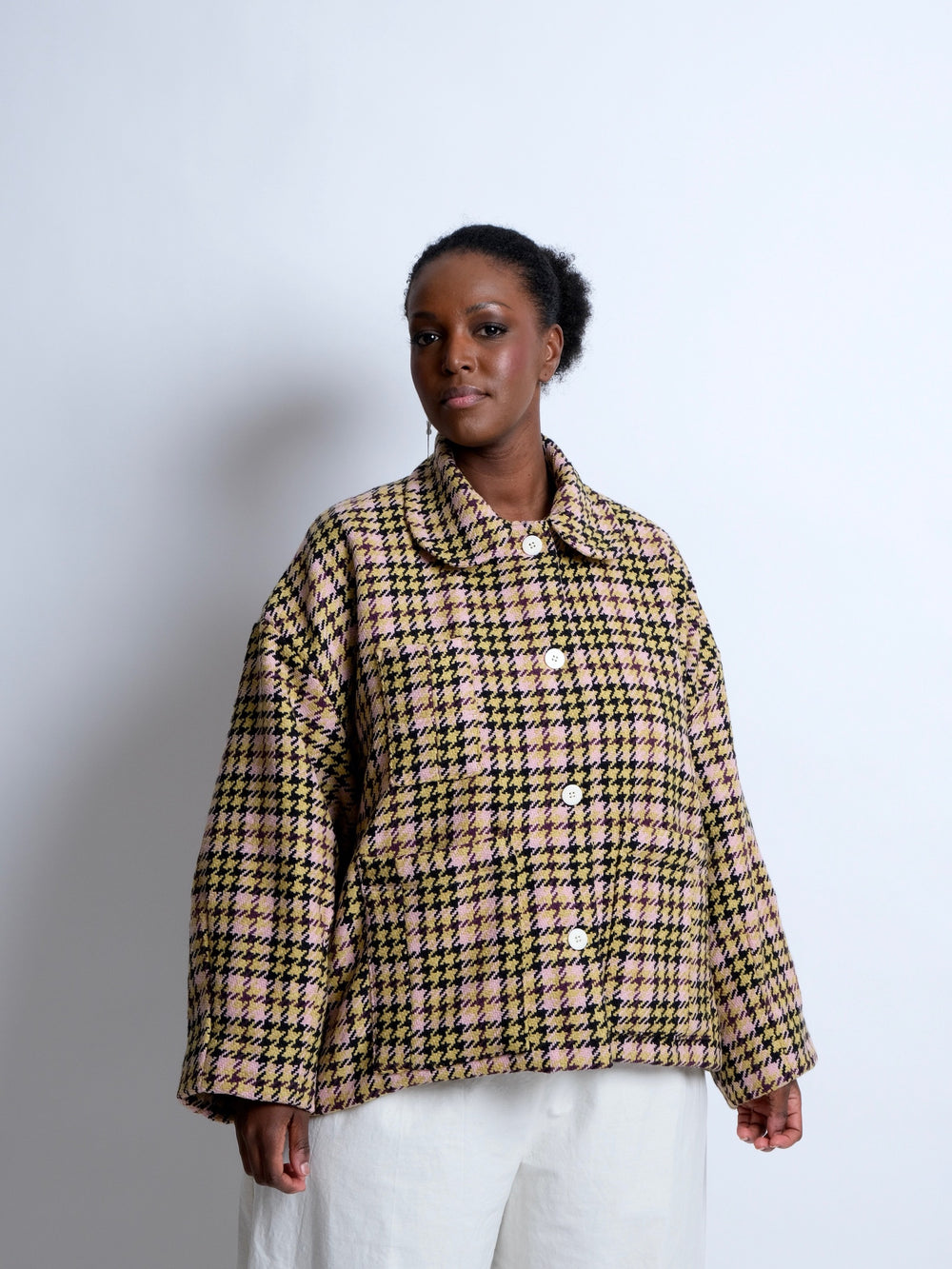 Woman wearing the ZW Bell Jacket sewing pattern from Birgitta Helmersson on The Fold Line. A lined jacket pattern made in wool, heavy weight denim or heavy cotton drill fabrics, featuring an oversized silhouette, rounded collar, front button closure, patc