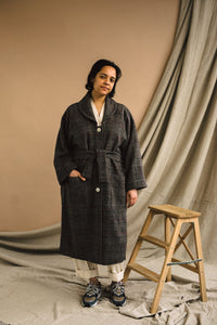 Woman wearing the Unisex ZW Coat sewing pattern from Birgitta Helmersson on The Fold Line. A semi fitted blouse pattern made in mid to heavy weight wool or heavy weight cotton drill fabrics, featuring an oversized silhouette, batwing sleeve, round collar,