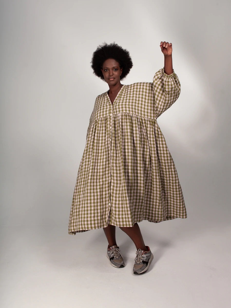 Woman wearing the ZW Gather Dress sewing pattern from Birgitta Helmersson on The Fold Line. A zero waste dress pattern made in woven linen or cotton fabrics, featuring an oversized silhouette, dropped shoulder, gathered skirt, side pockets, full length bu