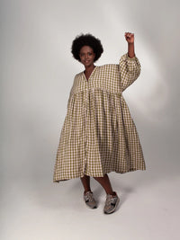 Woman wearing the ZW Gather Dress sewing pattern from Birgitta Helmersson on The Fold Line. A zero waste dress pattern made in woven linen or cotton fabrics, featuring an oversized silhouette, dropped shoulder, gathered skirt, side pockets, full length bu