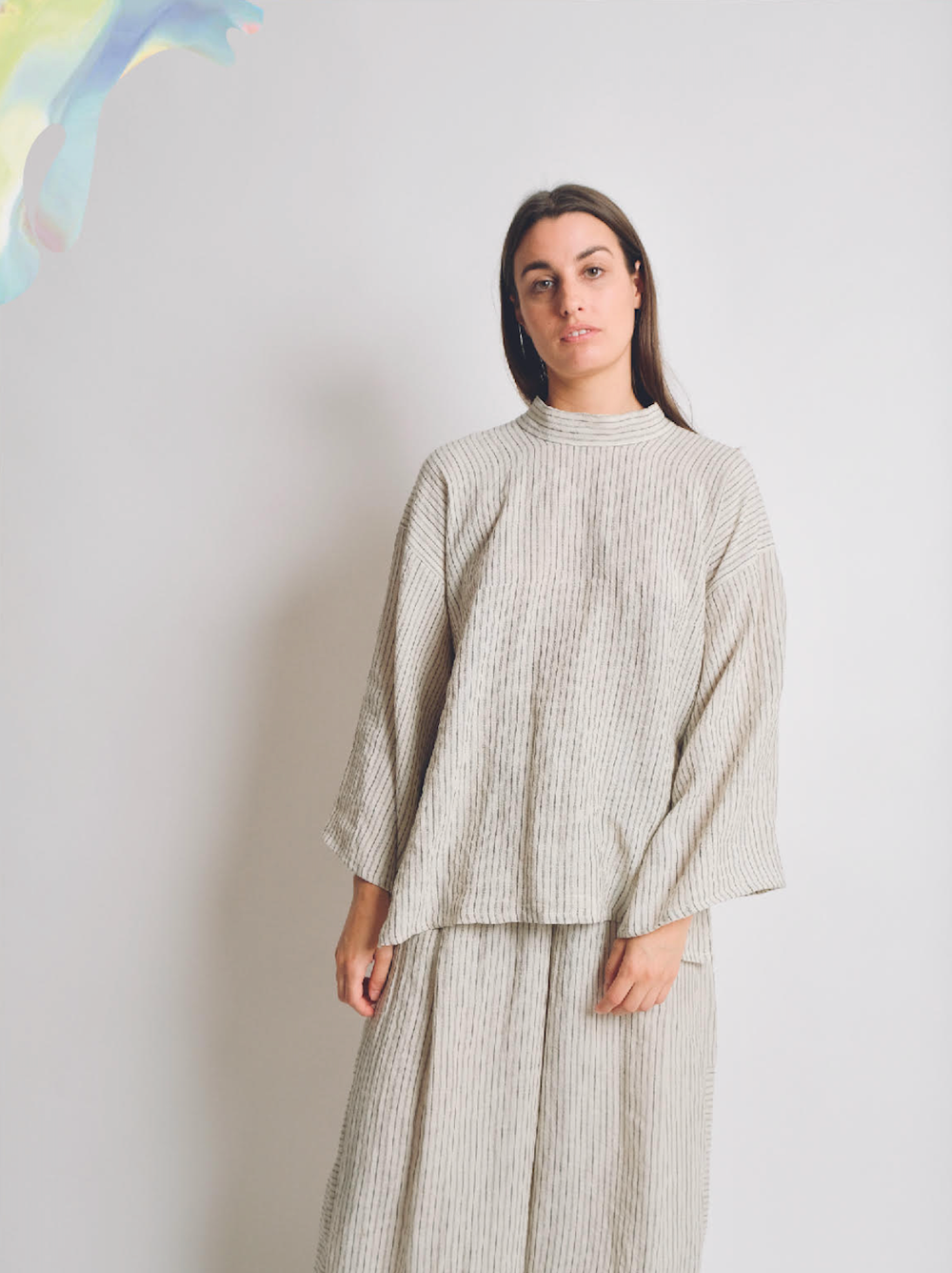 Woman wearing the ZW Tie Top sewing pattern from Birgitta Helmersson on The Fold Line. A top pattern made in light to mid weight cotton or linen, mid weight silk or viscose fabrics , featuring an oversized shape, relaxed fit, round high neck with attached